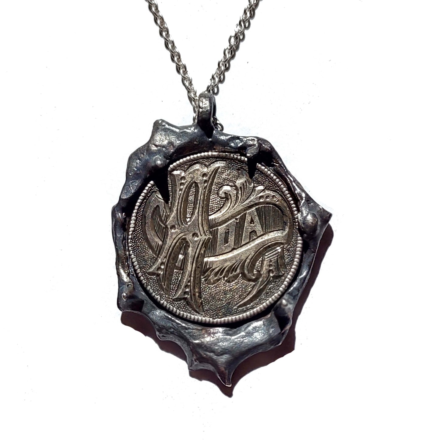 Ada love token pendant with intricate metal design on silver chain