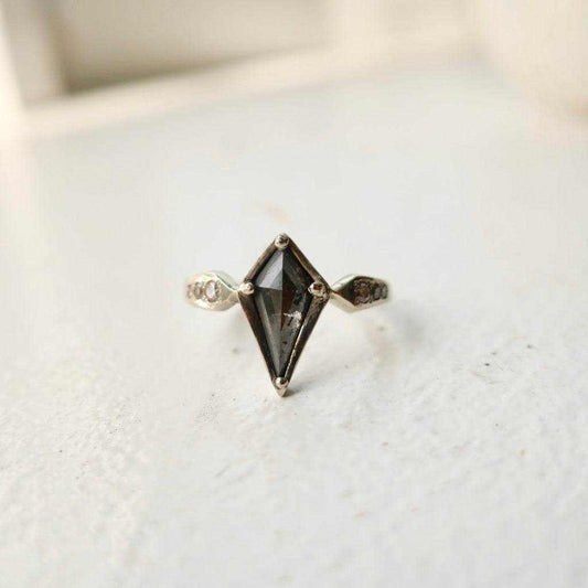Close-up of engagement ring featuring an unusual cut gemstone showcasing unique shapes and vibrant colors