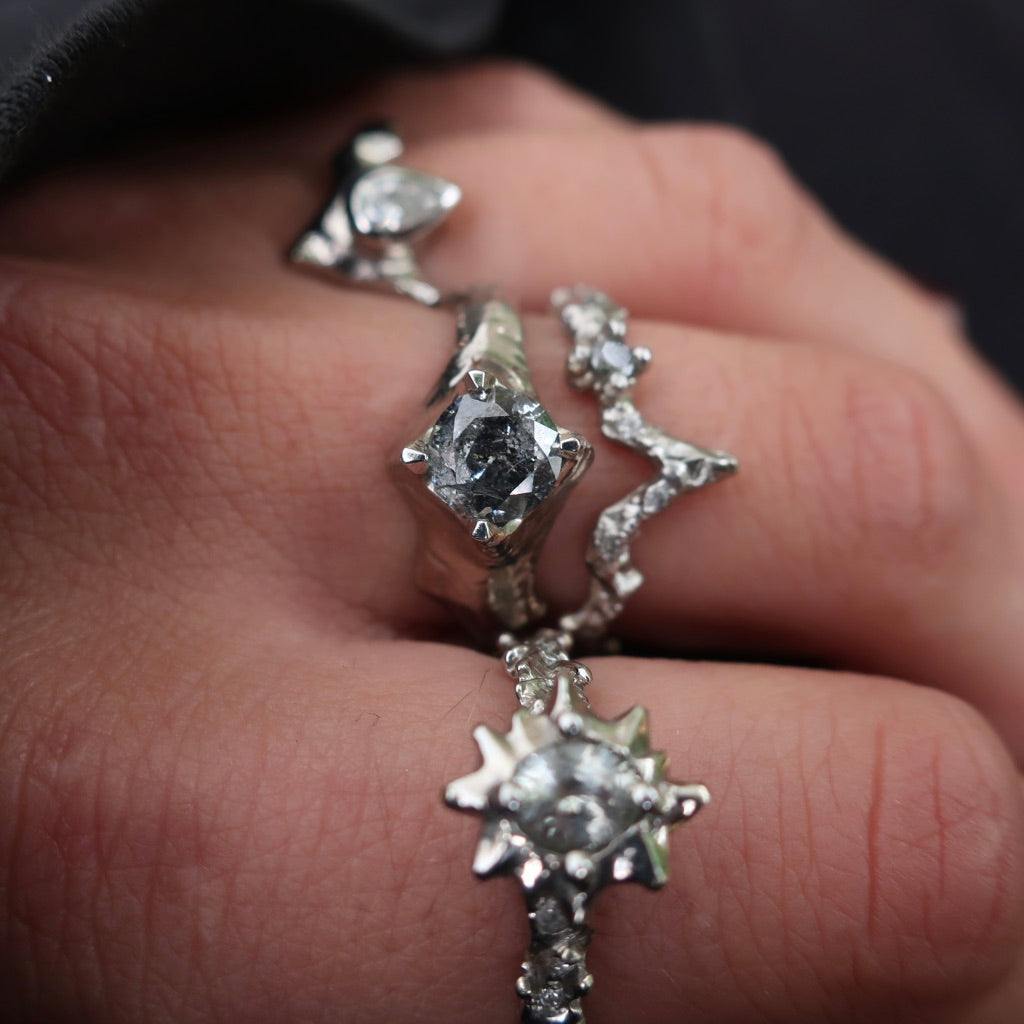 Close-up of a unique handmade engagement ring with a sparkling gemstone and intricate metalwork design